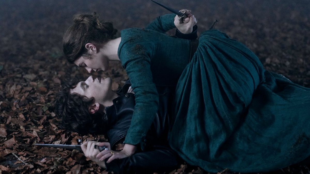 Emily Bader as Lady Jane Grey laying on top of Edward Bluemel as Guildford Dudley, they