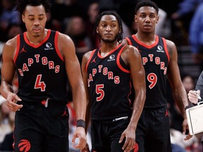 Scottie Barnes (4), Immanuel Quickley (5) et RJ Barrett (9) écoutent pendant la deuxième mi-temps de leur match NBA contre les Boston Celtics à la Scotiabank Arena le 15 janvier 2024, à Toronto.