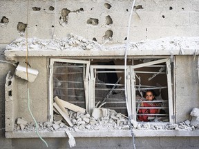 Un enfant palestinien regarde par la fenêtre d'un bâtiment endommagé lors d'une frappe israélienne sur le camp de réfugiés de Nuseirat, dans le centre de la bande de Gaza, le 6 juillet 2024.