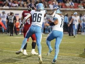 Le receveur des Argonauts de Toronto Damonte Coxie (86) célèbre son touché contre les Alouettes de Montréal avec le quart-arrière Cameron Dukes (11) lors de la première mi-temps du match de football de la LCF à Montréal, le jeudi 11 juillet 2024.