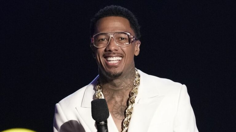 Nick Cannon wearing glasses and smiling on The Masked Singer