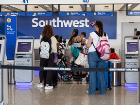 Les voyageurs s'enregistrent au comptoir Southwest de l'aéroport international Hartsfield-Jackson d'Atlanta à Atlanta, en Géorgie,