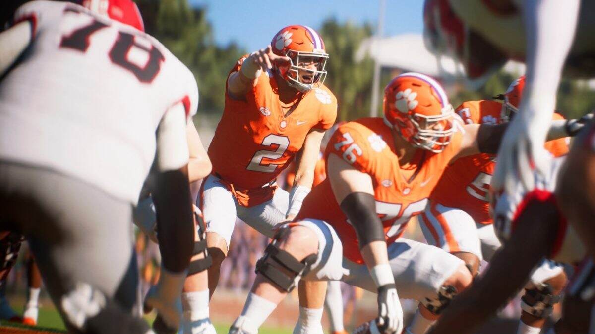 Critique de College Football 25 : Un groupe de joueurs de football en maillots orange entourés de joueurs en maillots blancs.