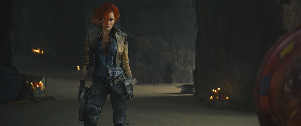 Cate Blanchett dans le rôle de Lillith dans Borderlands. Elle se tient prête dans un décor de grotte, tendant la main vers son pistolet dans son étui.