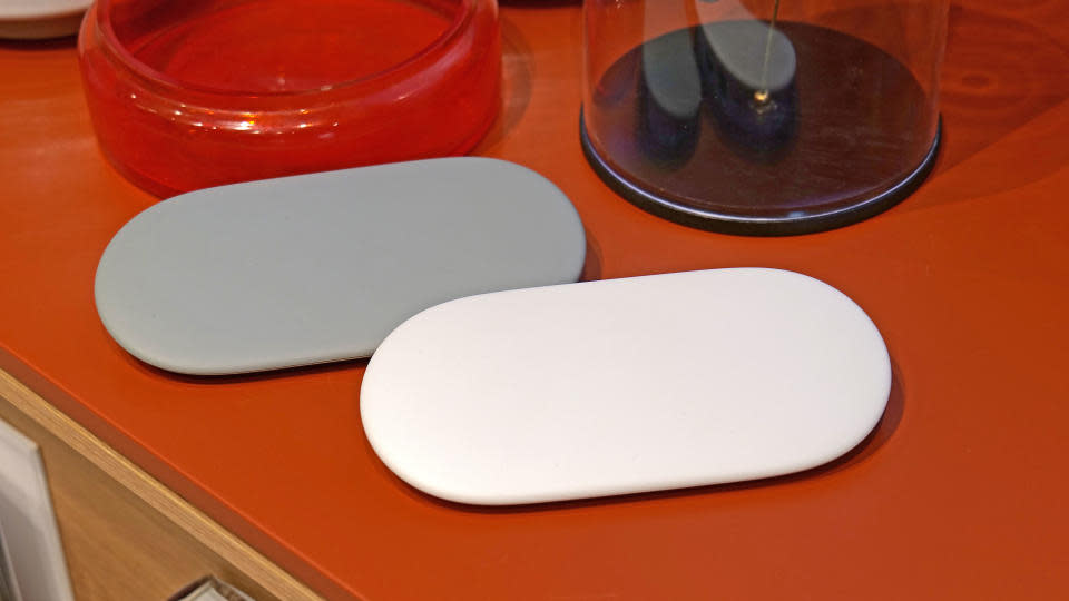 Deux appareils Google TV Streamer posés sur une table rouge.