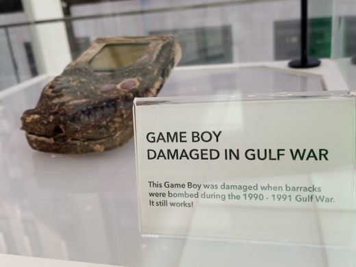 Une Game Boy brûlée est exposée dans une vitrine en verre dans un musée.