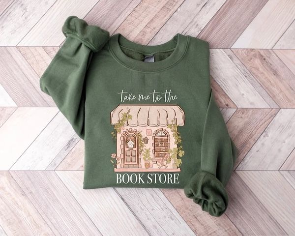 pull col rond vert militaire avec texte qui dit "Emmène-moi à la librairie" disposé autour d'un graphique représentant une devanture de librairie 