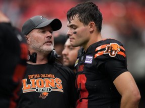 L'entraîneur-chef des Lions de la Colombie-Britannique, Rick Campbell, à gauche, parle au quart-arrière Nathan Rourke sur la ligne de touche pendant la deuxième mi-temps d'un match de football de la LCF contre les Blue Bombers de Winnipeg, dimanche.