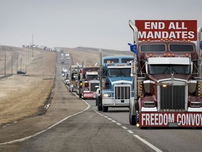 Des manifestants anti-vaccination contre la COVID-19 partent dans un convoi de camions après avoir bloqué l'autoroute au poste frontière américain très fréquenté de Coutts, en Alberta, le mardi 15 février 2022. Une audience de détermination de la peine est prévue cette semaine pour deux hommes reconnus coupables de méfaits lors du blocus frontalier de 2022 près de Coutts.