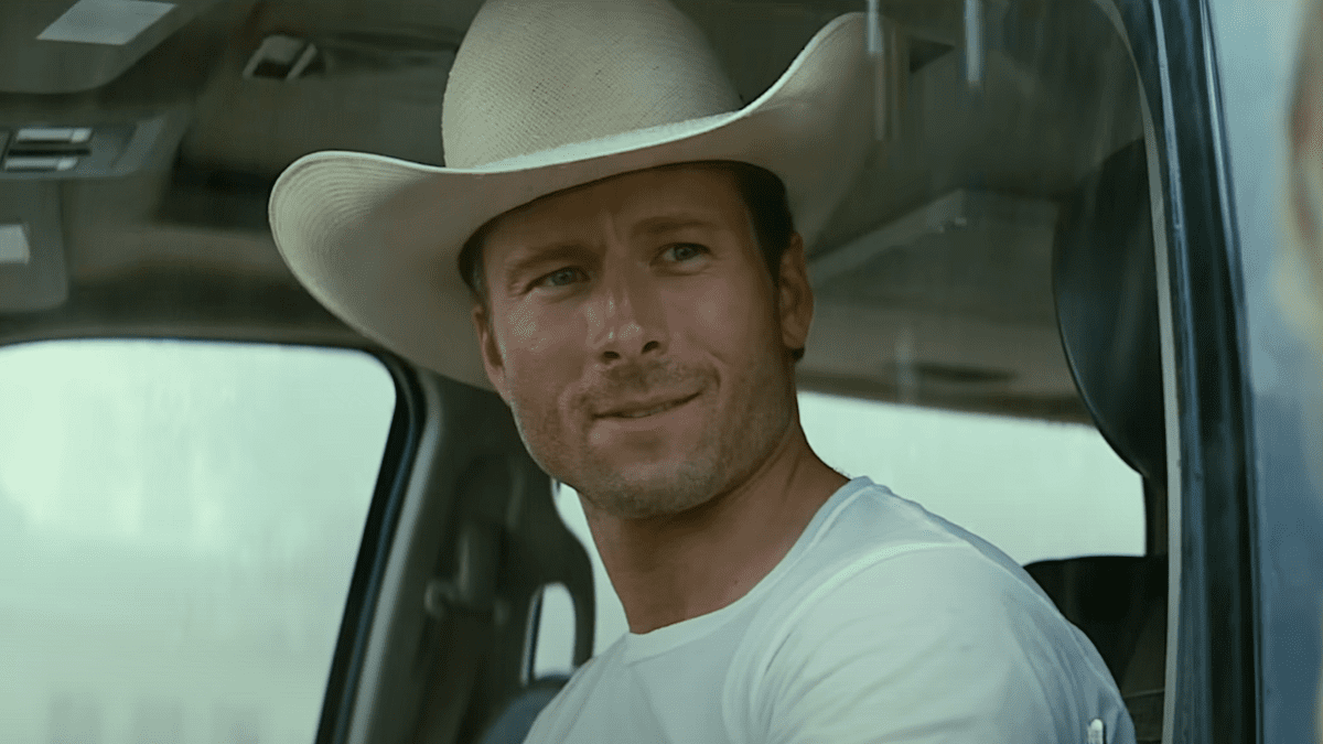 Glen Powell wearing a cowboy hat and driving a car in Twisters 