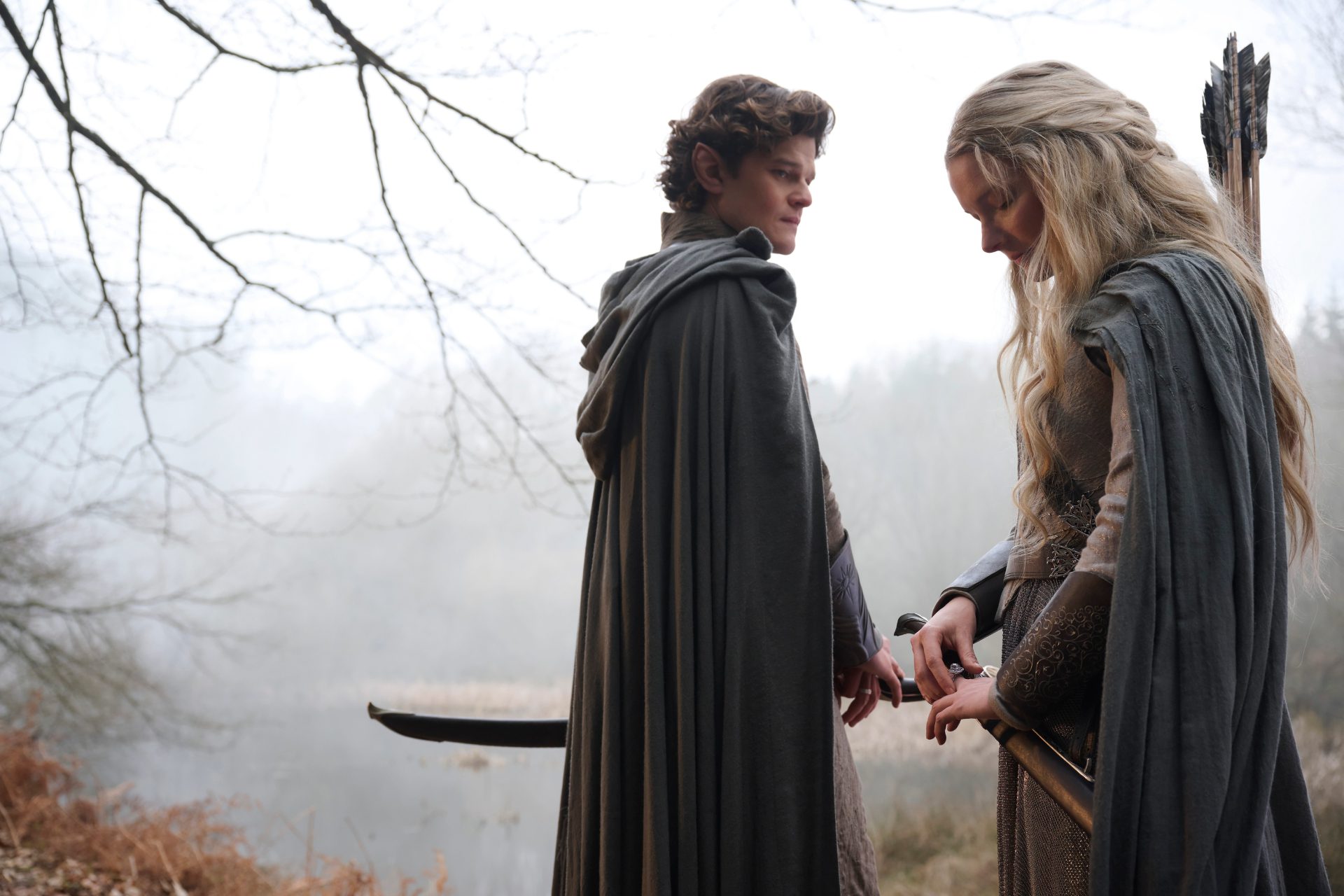 Elrond (Robert Aramayo) and Galadriel (Morfydd Clark) stand in a foggy wood in The Rings of Power season 2