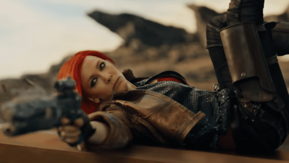 Cate Blanchett aiming a gun while lying on herb back in Borderlands