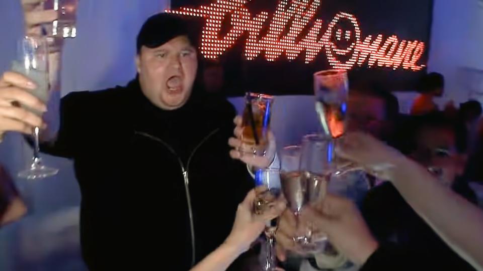 Kim Dotcom fait la fête, trinque avec d'autres personnes dans une ambiance de club. Extrait du clip vidéo.