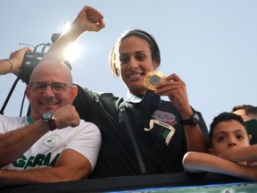 La médaillée d'or algérienne Imane Khelif salue la foule lors d'une tournée en bus dans sa ville natale de Tiaret, le 16 août 2024.