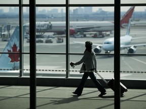 Un voyageur passe devant des avions d'Air Canada à l'aéroport international Pearson de Toronto.