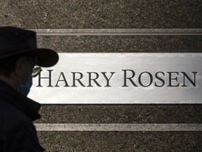 Un piéton passe devant la signalisation de Harry Rosen sur la rue Bloor à Toronto le 8 mars 2022.