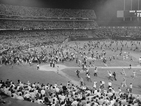 Les fans affluent sur le terrain de l'Oakland Coliseum après que les Oakland A aient battu les Los Angeles Dodgers 3-2 et remporté leur troisième Série mondiale consécutive, le 17 octobre 1974, à Oakland. (Fichier AP)