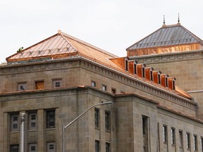 Un ouvrier du bâtiment est vu sur le toit en cuivre restauré de l'édifice commémoratif de l'Ouest à Ottawa le 19 octobre 2022.