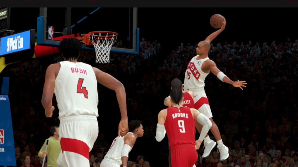 Capture d'écran de NBA 2K25 Arcade Edition. Recréation d'un jeu vintage avec Vince Carter (ère des Raptors) se levant pour un slam tandis que Chris Bosh court le long de l'aile gauche.