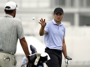 Jordan Spieth, à droite, attrape une balle qui lui est lancée sur le practice du tournoi de golf du championnat St. Jude, le mercredi 14 août 2024, à Memphis, Tennessee.