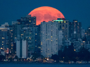 La lune flotte au-dessus de l'horizon de Vancouver. La ville de la côte ouest et Toronto ressemblent aux marchés immobiliers mondiaux comme ceux de New York et de Londres.