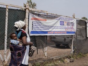 Une femme passe devant un panneau indiquant « Stop Monkeypox » dans une clinique de Munigi, dans l'est du Congo, le vendredi 16 août 2024.