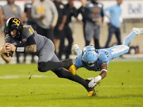 Le quart-arrière des Tiger-Cats de Hamilton, Bo Levi Mitchell, est plaqué par le demi défensif des Argonauts de Toronto, Royce Metchie, lors de la deuxième mi-temps d'un match de football de la LCF à Toronto, le 20 septembre 2024.