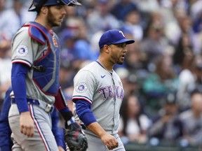 Sur cette photo d'archives, le receveur des Texas Rangers Jonah Heim revient au monticule avec le lanceur de relève Gerson Garabito, à droite, après un simple de Luke Raley des Mariners de Seattle lors de la huitième manche d'un match de baseball, le dimanche 15 septembre 2024, à Seattle.