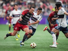 Federico Bernardeschi du Toronto FC, à l'avant gauche, et Andres Cubas des Whitecaps de Vancouver se disputent le ballon lors de la première mi-temps de football de la MLS à Vancouver, en Colombie-Britannique, le samedi 6 avril 2024.