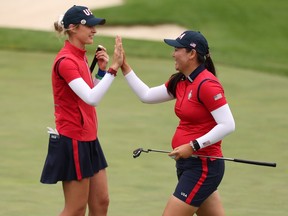 Allisen Corpuz (à droite) et Nelly Korda de l'équipe des États-Unis réagissent à un putt sur le 14e green lors des matchs de Foursomes du vendredi contre l'équipe Europe lors du premier tour de la Solheim Cup.