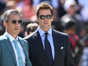 Les commentateurs Kevin Burkhardt (à gauche) et Tom Brady (à droite) marchent le long du terrain avant le match entre les Cowboys de Dallas et les Browns de Cleveland.