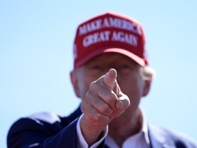 L'ancien président Donald Trump, candidat républicain à la présidence, fait un geste lors d'un événement de campagne à l'aéroport du centre du Wisconsin, le samedi 7 septembre 2024, à Mosinee, Wisconsin.