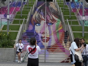 Des fans posent devant un portrait de Taylor Swift peint sur un escalier du stade de Wembley à Londres, le mercredi 14 août 2024, avant une série de concerts de Taylor Swift à partir de jeudi.