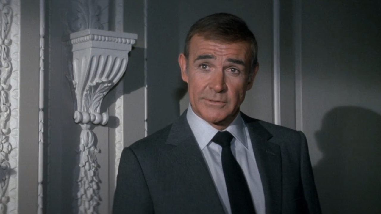 Sean Connery debout dans le bureau de M en conversation dans Never Say Never Again.