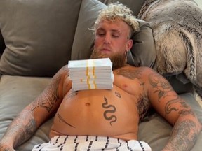 Jake Paul pose avec une pile d'argent.