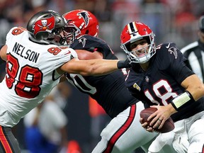 Anthony Nelson, à gauche, des Buccaneers de Tampa Bay, limoge Kirk Cousins, à droite, des Falcons d'Atlanta au cours du troisième quart-temps au stade Mercedes-Benz, le 3 octobre 2024 à Atlanta, en Géorgie.