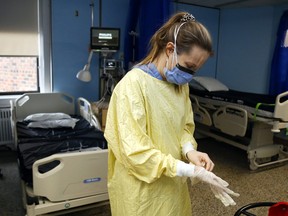 Une infirmière autorisée enfile des gants et d'autres équipements de protection individuelle dans l'unité de soins spéciaux de l'hôpital Campbellford Memorial à Campbellford, en Ontario.