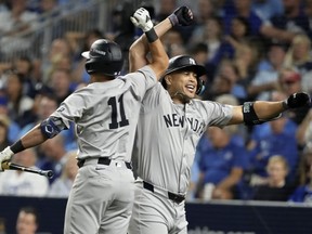 Giancarlo Stanton des Yankees, à droite, et Anthony Volpe, à gauche, célèbrent après que Stanton ait frappé un circuit lors de la huitième manche contre les Royals lors du troisième match d'une série de division AL au stade Kauffman à Kansas City, Missouri, le mercredi 9 octobre. , 2024.