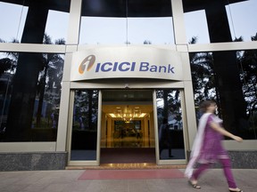 Une femme passe devant l’entrée du siège social d’ICICI Bank Ltd. à Mumbai, en Inde.