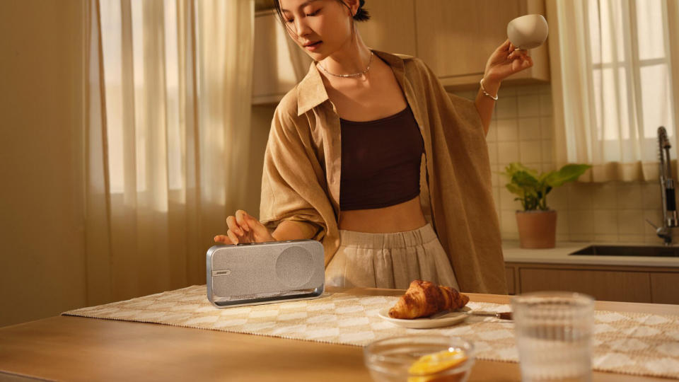 Une personne utilisant l’enceinte Bose SoundLink Home pendant qu’elle cuisine dans une cuisine.