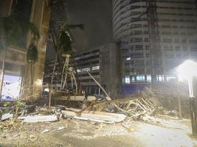 Des débris recouvrent le sol près d'une grue tombée sur un bâtiment le long de la 1ère Avenue Sud à Saint-Pétersbourg, en Floride, alors que les vents violents de l'ouragan Milton ont dévasté la zone le jeudi 10 octobre 2024.