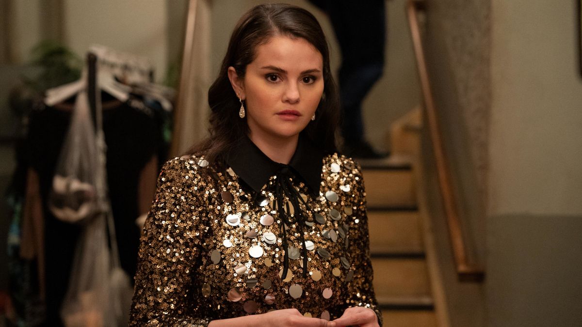 Selena Gomez stands with a look of concern in a gold and black sequin dress in Only Murders in the Building.