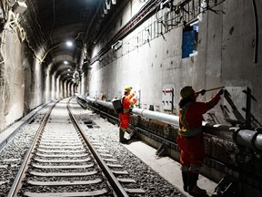 Des travailleurs inspectent les murs du tunnel du Mont-Royal alors que progresse la construction d'un système de train léger sur rail électrique à Montréal, le mercredi 1er mai 2024.