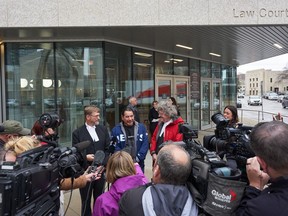 L'avocat Jerome Kennedy, de gauche à droite, a acquitté le coaccusé Brian Anderson, et l'avocat James Lockyer s'adressent aux médias devant le palais de justice au sujet de l'audience de libération de Clarence Woodhouse à Winnipeg, le lundi 23 octobre 2023.